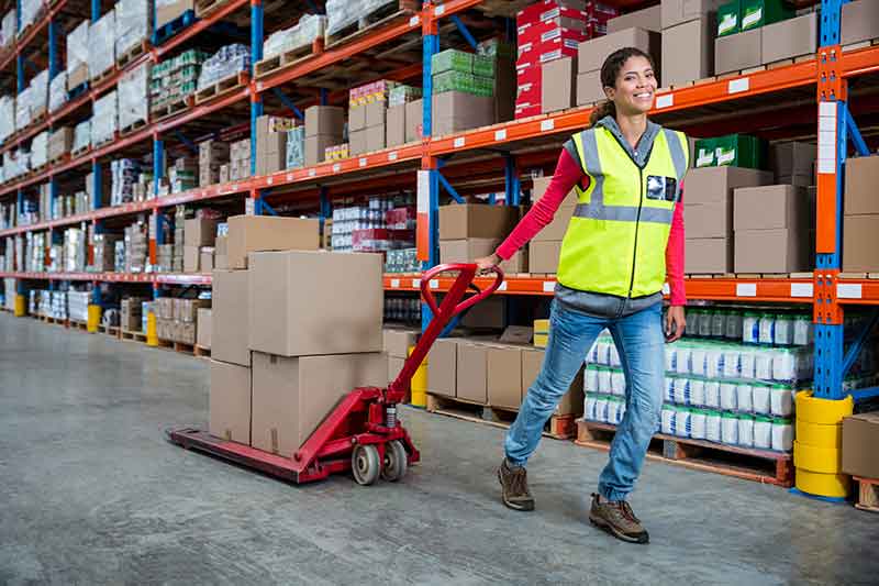Female warehouse worker moving packages